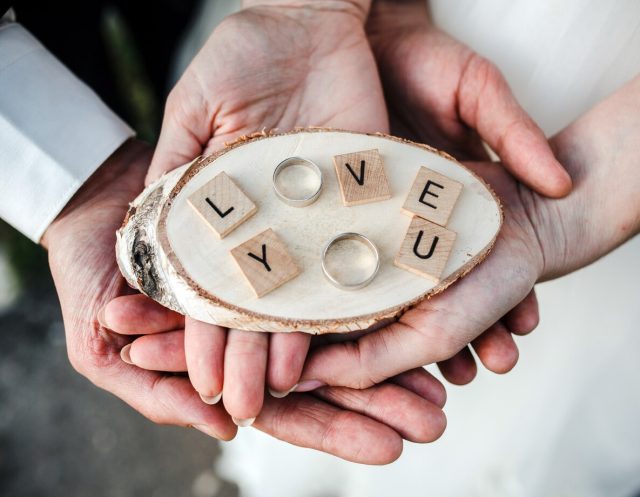 top-view-couple-holding-wedding-rings_1153-595